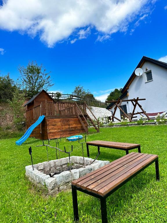park z dwoma ławkami i placem zabaw w obiekcie Domek u Beaty w Kudowie Zdroju