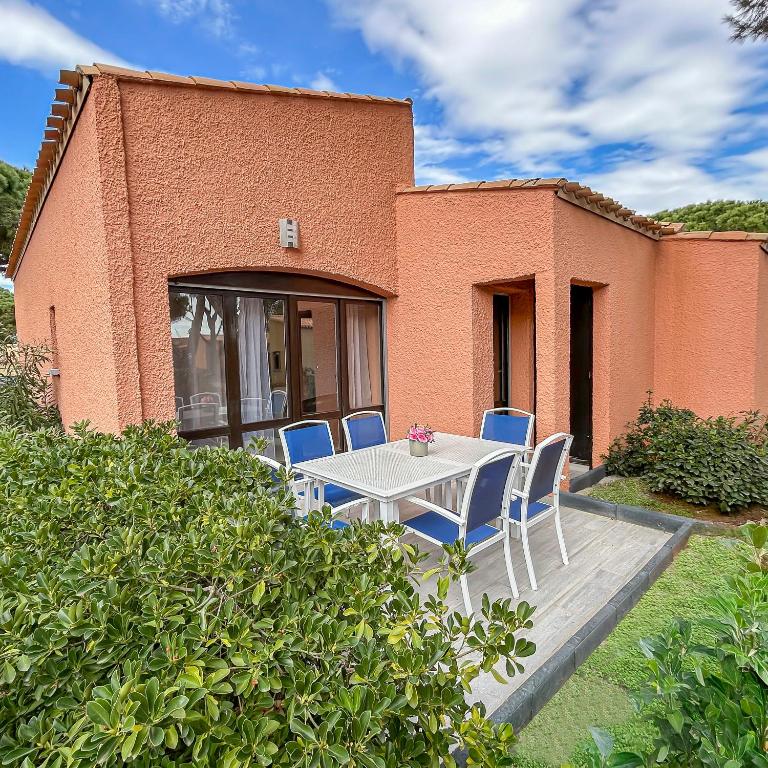 une table et des chaises devant une maison dans l'établissement Terrasse privée, piscine, à 5 mn de la plage, au Cap d'Agde
