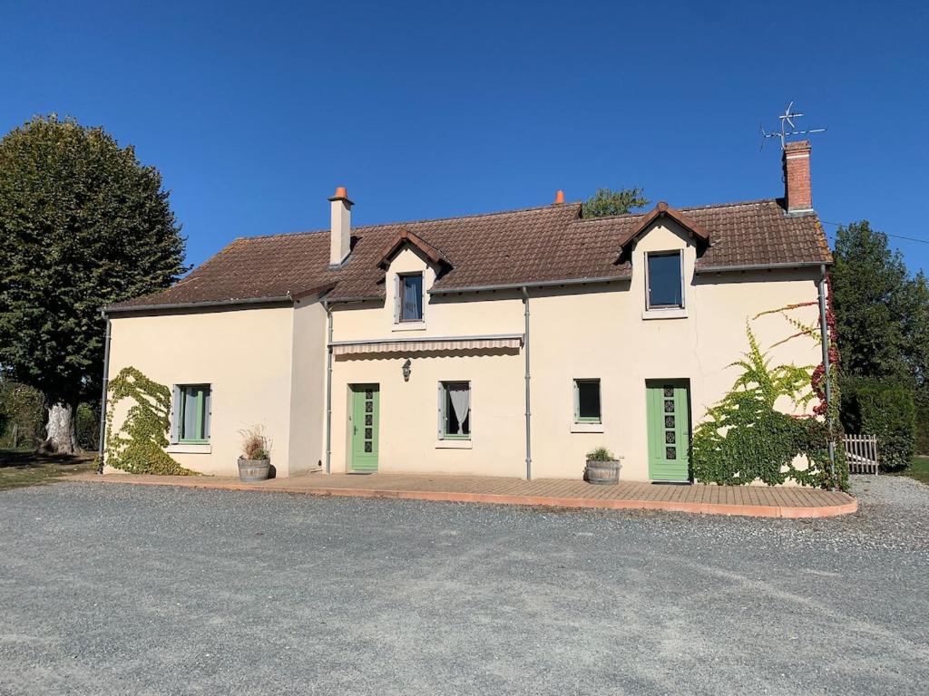 a large white house with green shutters at Les Vendanges Maison Vigneronne in Reuilly