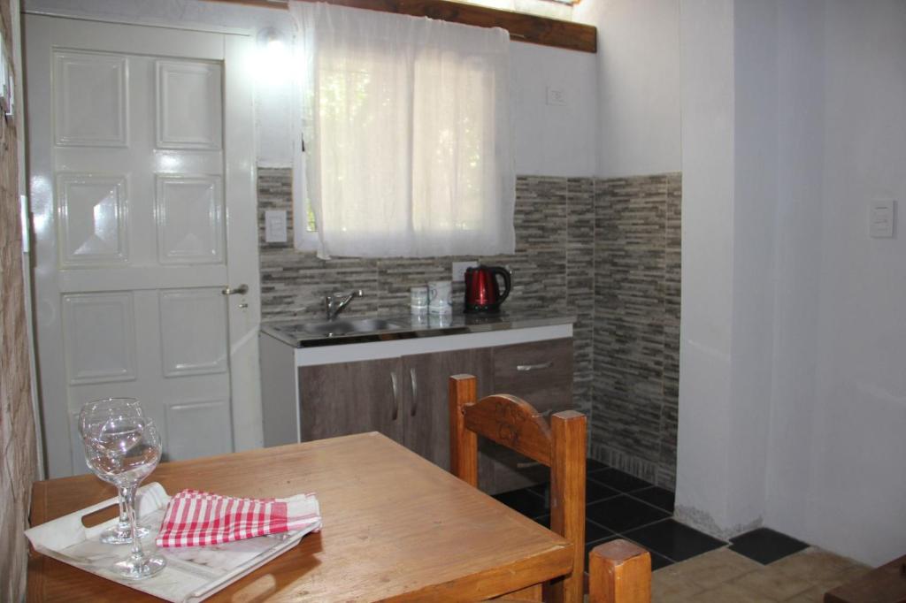 a kitchen with a wooden table with a wine glass at La Damasca 1 in General Roca