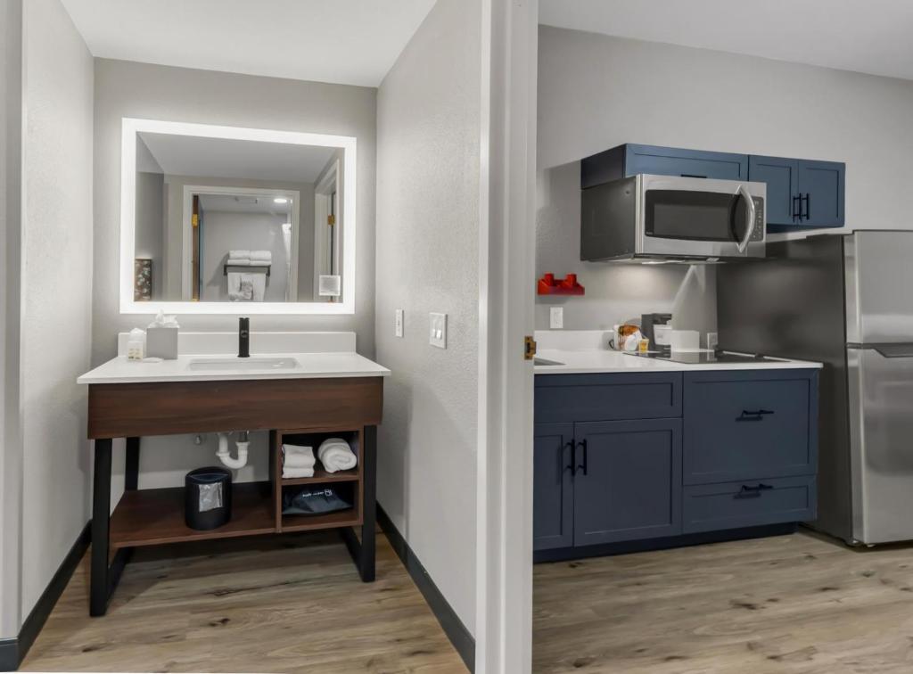 a kitchen with blue cabinets and a sink at Hawthorn Extended Stay by Wyndham College Station in College Station