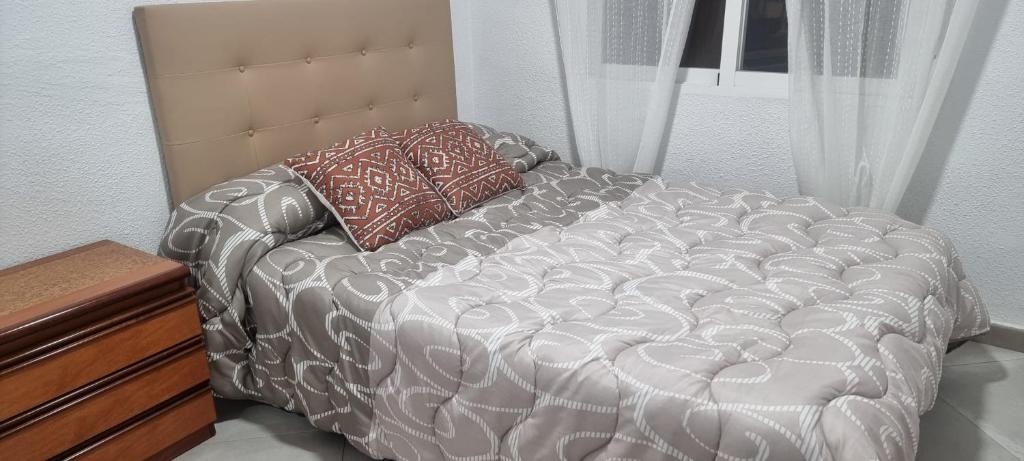 ein Bett mit zwei Kissen darauf in einem Zimmer in der Unterkunft Habitación Matrimonio cerca a la Playa de Poniente in Benidorm