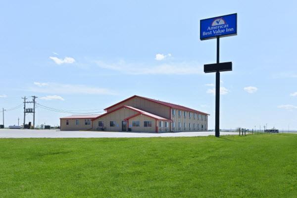 a building with a sign in the middle of a field at Americas Best Value Inn Kadoka in Kadoka
