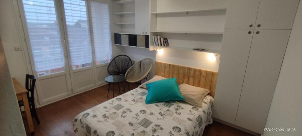 - une chambre dotée d'un lit avec un oreiller vert dans l'établissement Joli F1 au coeur de Paray, à Paray-le-Monial