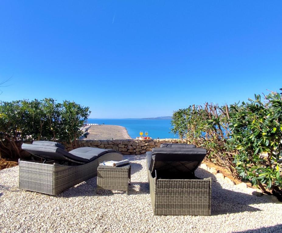 a group of wicker chairs and tables on a beach at Blauer Horizont in Povljana