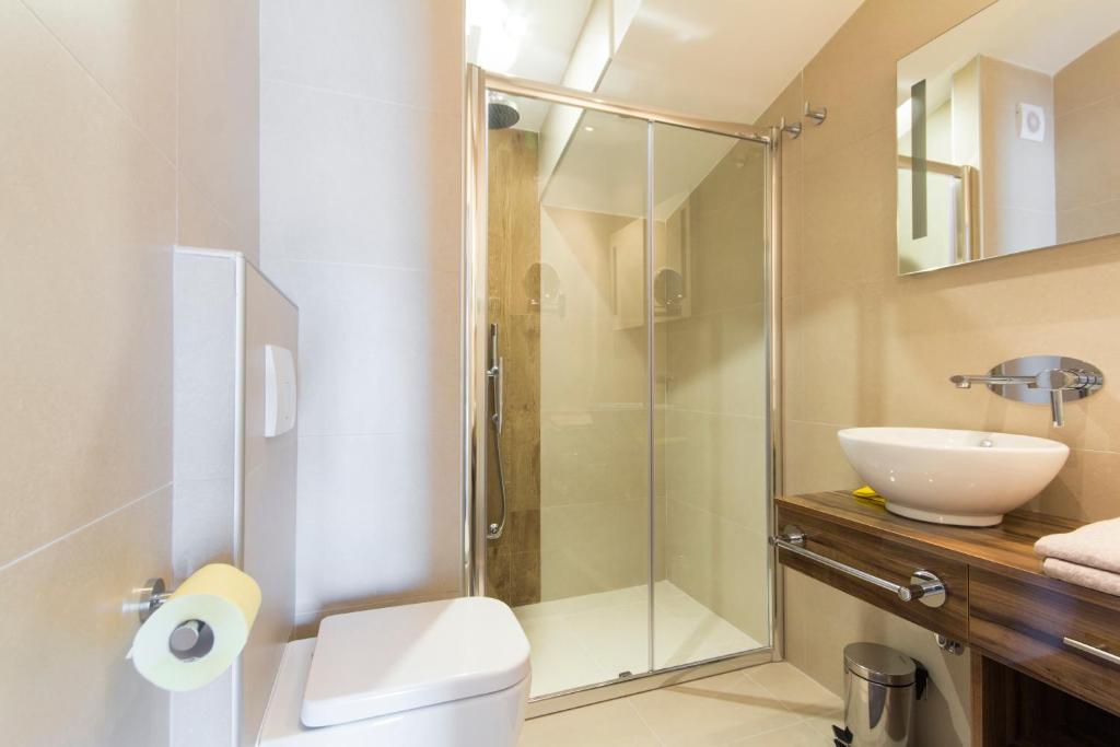 a bathroom with a shower and a toilet and a sink at Alison Apartments in Premantura