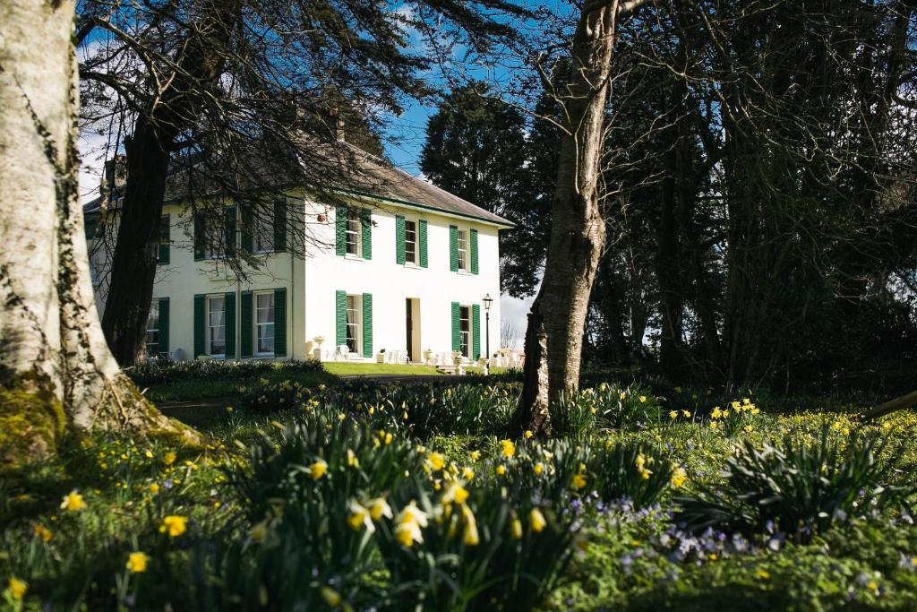 a white house with flowers in front of it at Elm Grove Country House in Tenby
