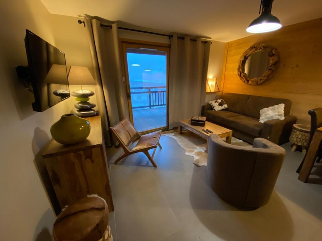 a living room with a couch and a television at Appartement 6 personnes pied des pistes in Les Deux Alpes