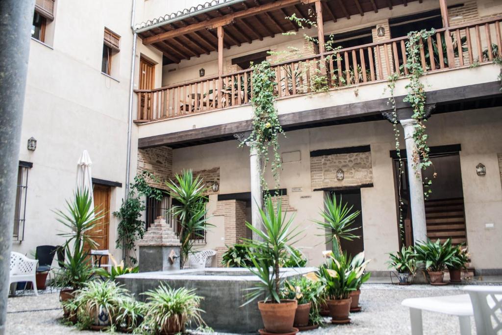 un patio de un edificio con macetas en Abadia Suites, en Granada