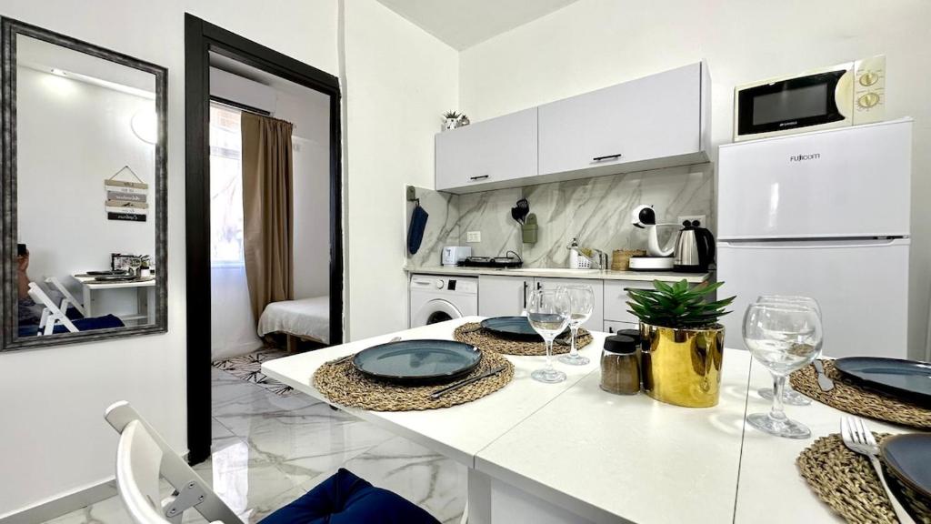 a kitchen with a counter with plates and glasses on it at Beautyful Resort Apartment in Haifa