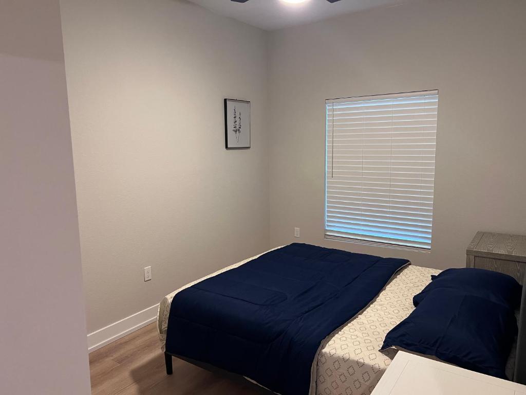 a bedroom with a bed with blue sheets and a window at New home near beautiful beaches in Port Charlotte