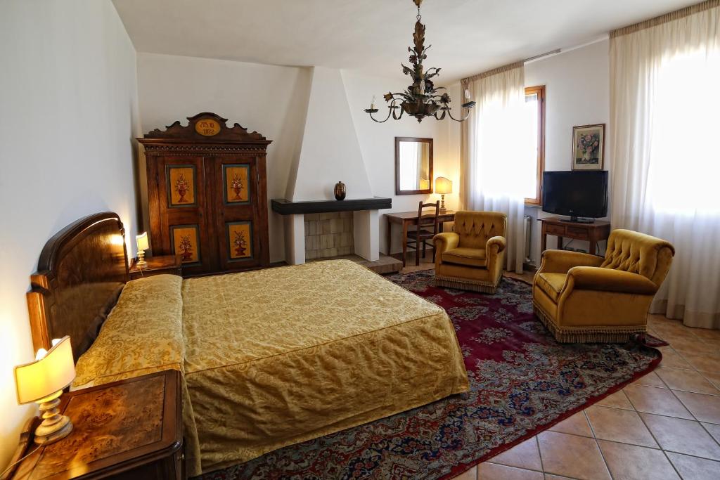 sypialnia z łóżkiem, krzesłami i telewizorem w obiekcie Hotel Luna w mieście San Felice sul Panaro