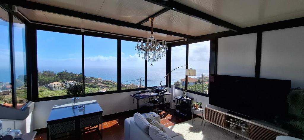 a living room with large windows with a view of the ocean at Sally's Loft - Penthouse - Honeymoon suite in Ponta do Sol