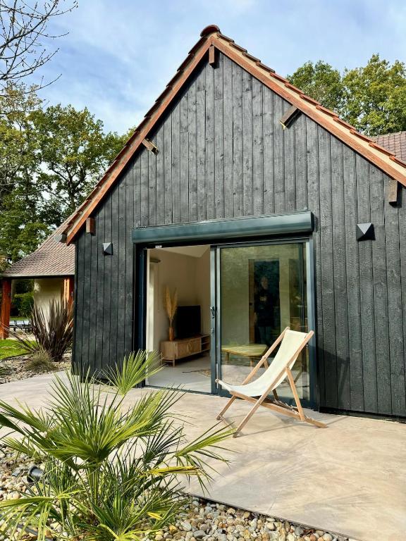 une maison noire avec une porte coulissante en verre dans l'établissement Dépendance de charme entre Disney et Paris, à Pomponne