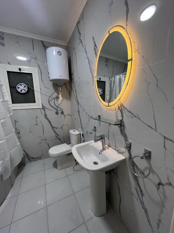 a white bathroom with a sink and a mirror at فيلا في مدينتي in Madinaty