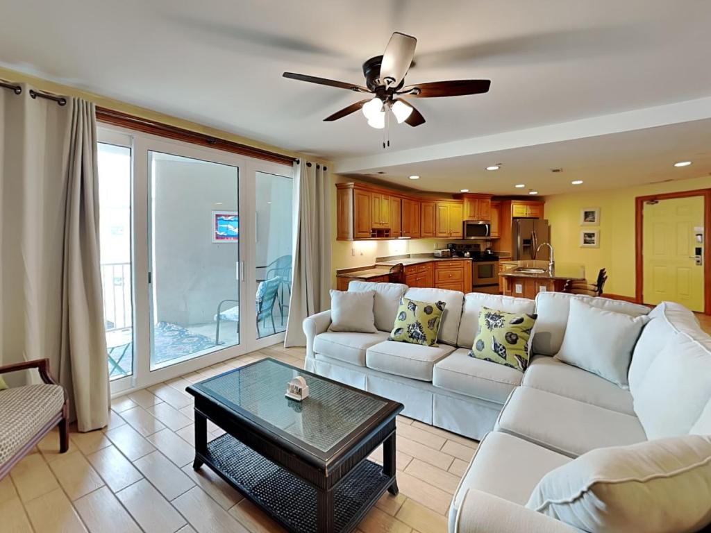 una sala de estar con un sofá y una mesa en Tybee Beach Club 137, en Tybee Island