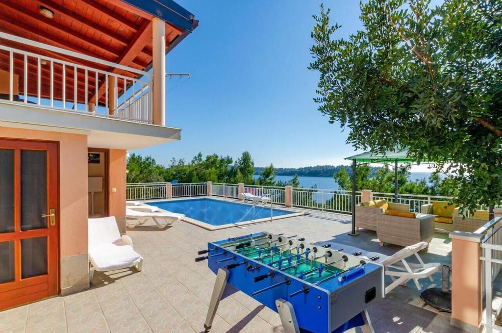 a house with a blue table and a pool at House Vila Petra in Blato
