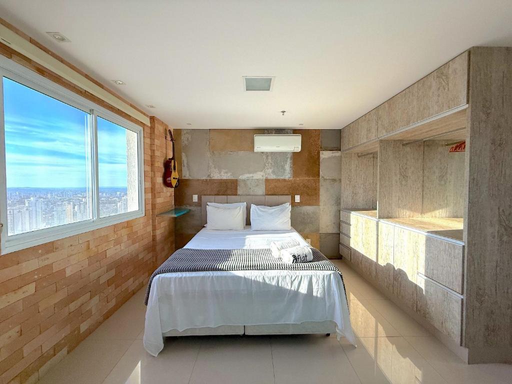 a bedroom with a bed and a large window at iFlat brookfield Towers BTLX2817 Jardim Goiás in Goiânia
