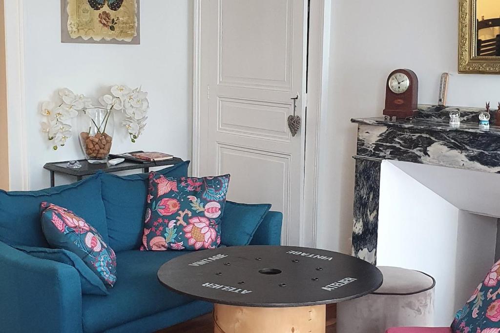 un salon avec un canapé bleu et une table dans l'établissement APPARTEMENT T2 4 PERSONNES Wifi et Climatisation, à Luchon