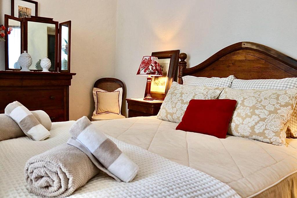 a bedroom with a large white bed with a red pillow at A Casa dos Raminhos in Vila de Frades