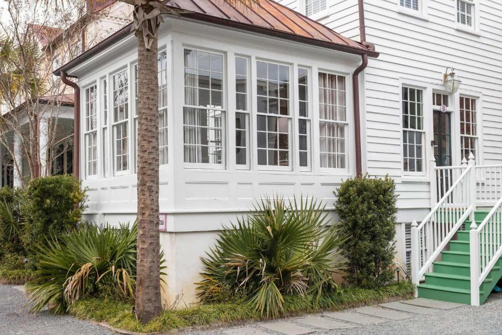 a white house with a window and some plants at Solarium at Cassa Zoe in Charleston