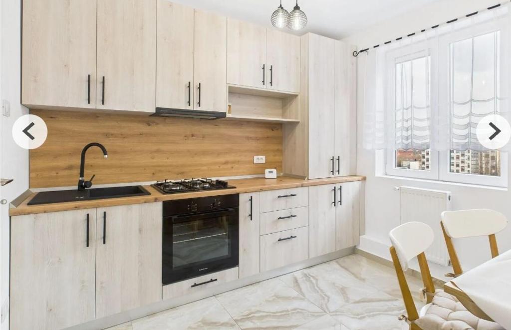 a kitchen with white cabinets and a sink and a stove at Unique apartments in Timişoara