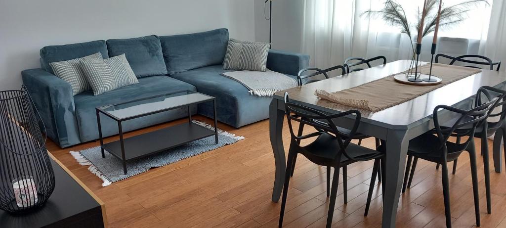 salon ze stołem i niebieską kanapą w obiekcie AnJa Apartment w mieście Sandomierz