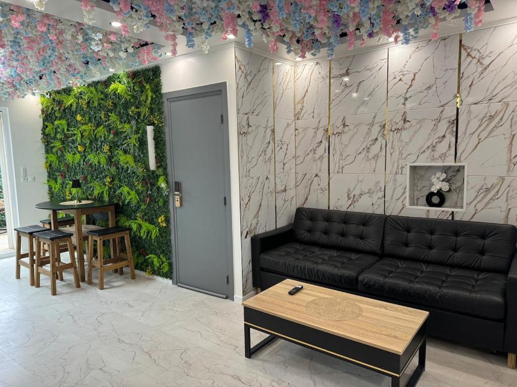 - un salon avec un canapé noir et un mur vert dans l'établissement Apartment with jacuzzi, à Lille