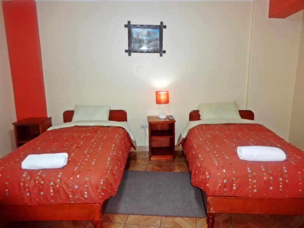 2 posti letto in una camera con lenzuola rosse di Hatun Wasi Huaraz a Huaraz