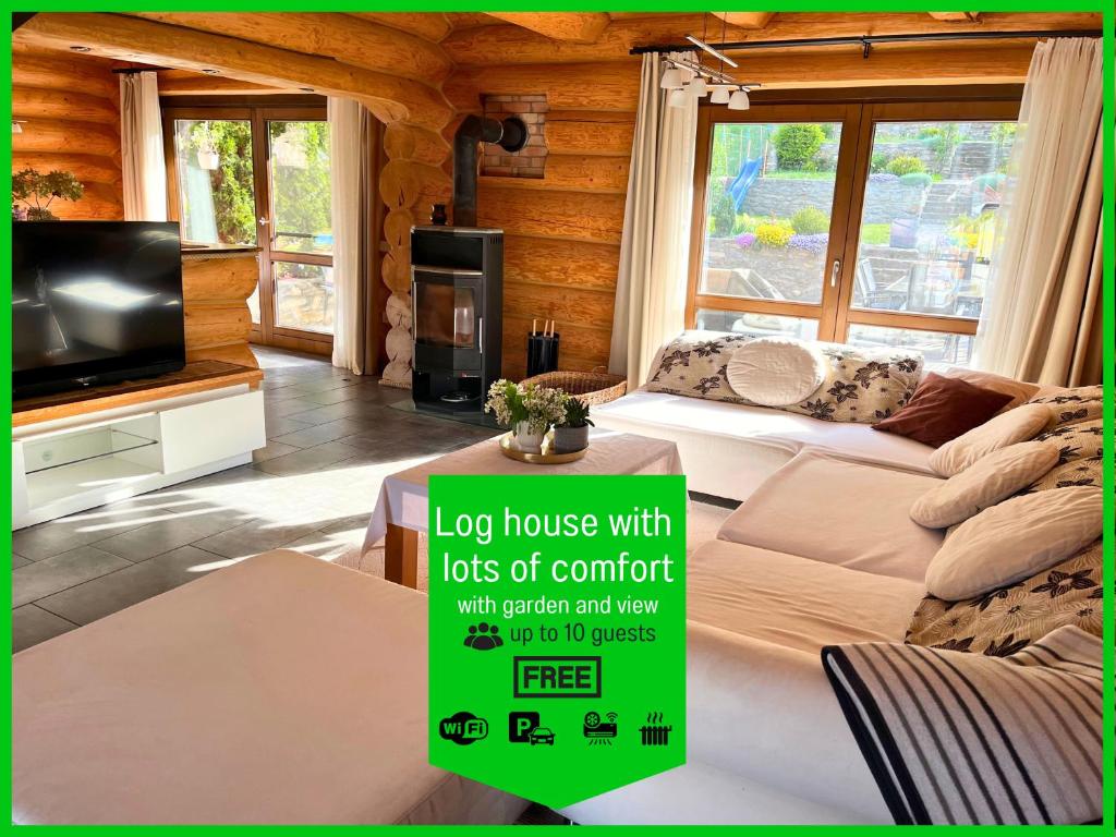 a log house with lots of comfort with better furniture and a tv at Blockhaus Malmkrog with garden, bright rooms, and an open kitchen in Mălîncrav