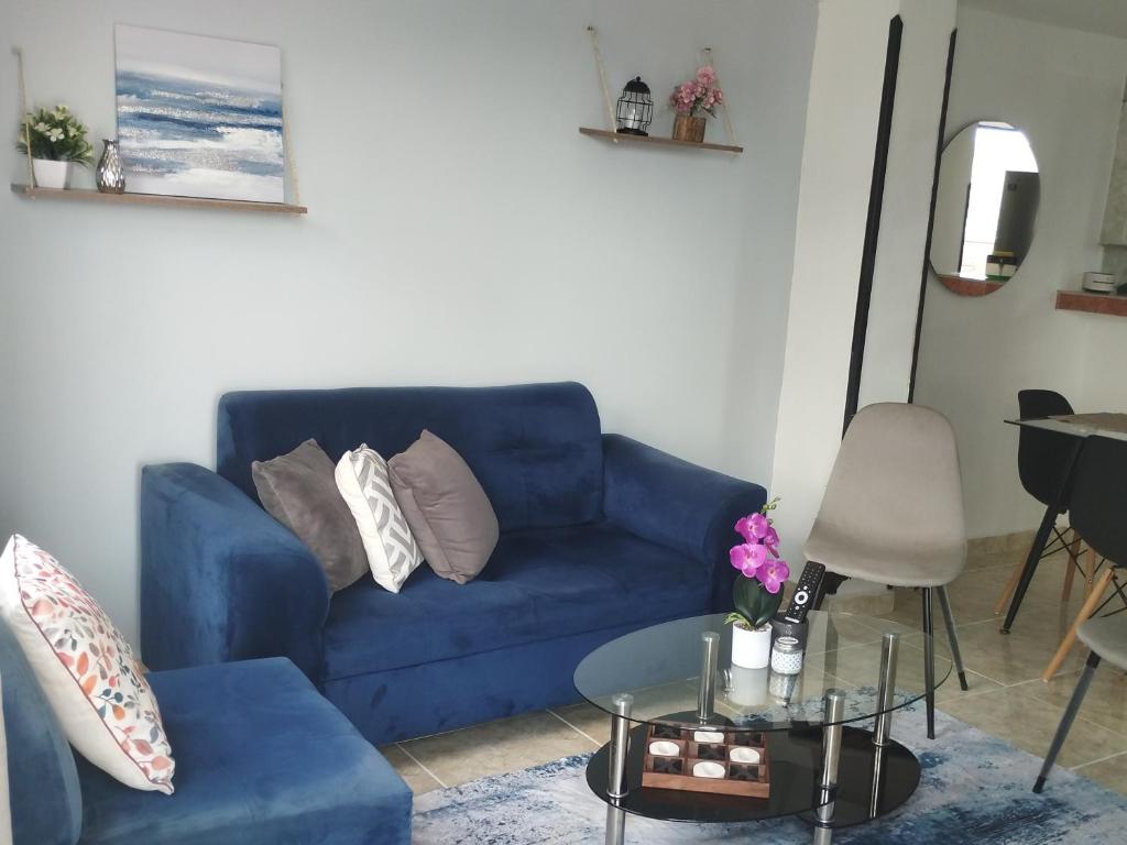 un canapé bleu dans un salon avec une table dans l'établissement Apto piso 2 amoblado en Bucaramanga, à Bucaramanga