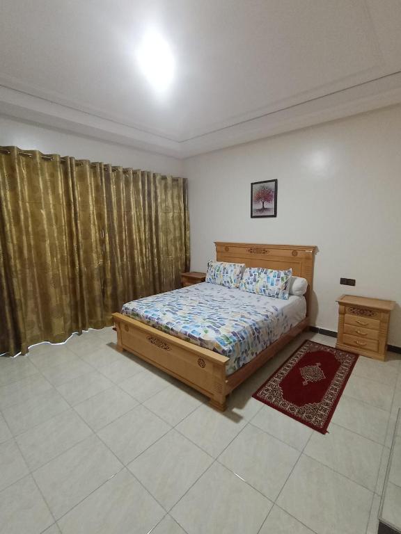 a bedroom with a bed and a window with curtains at résidence sara in Fez