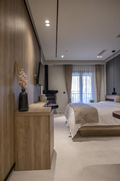 a bedroom with a large bed and a piano at Polyzos Luxury Suites Meteora #4 - Adults Friendly in Kalabaka