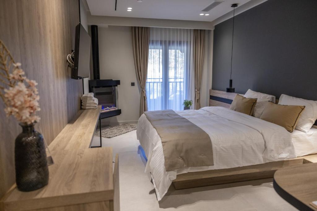 a bedroom with a large bed and a tv at Polyzos Luxury Suites Meteora #4 - Adults Friendly in Kalabaka
