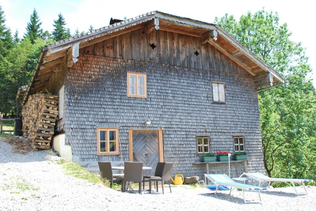 eine Scheune mit einem Tisch und Stühlen davor in der Unterkunft Schipplbadstube in Annaberg im Lammertal