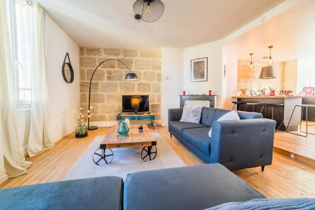 un salon avec deux canapés bleus et une table dans l'établissement Dalissimo - 1 Chambre, à Brive-la-Gaillarde