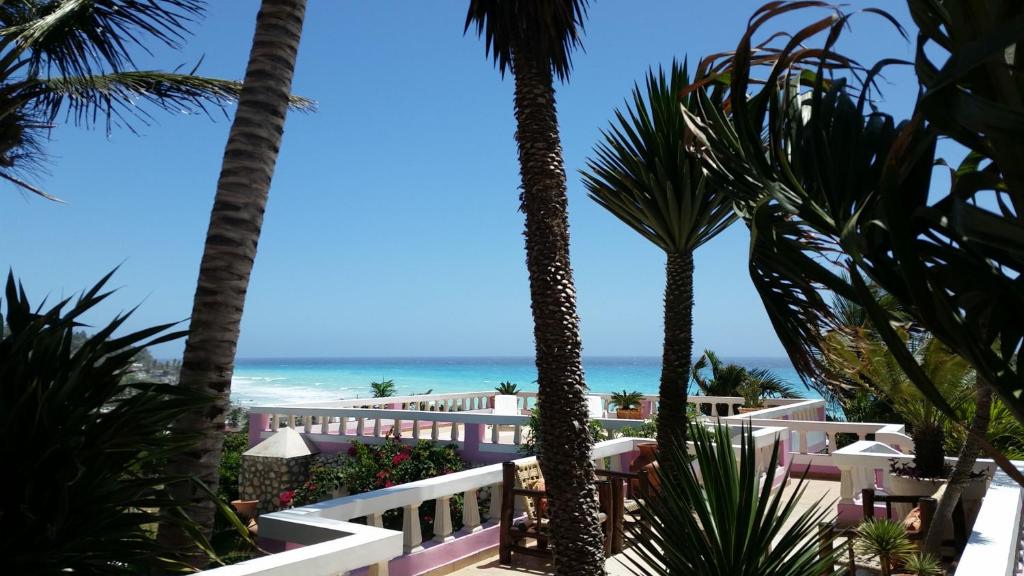 uma vista para a praia a partir de um resort com palmeiras em Ecolodge Vistamar em Los Patos