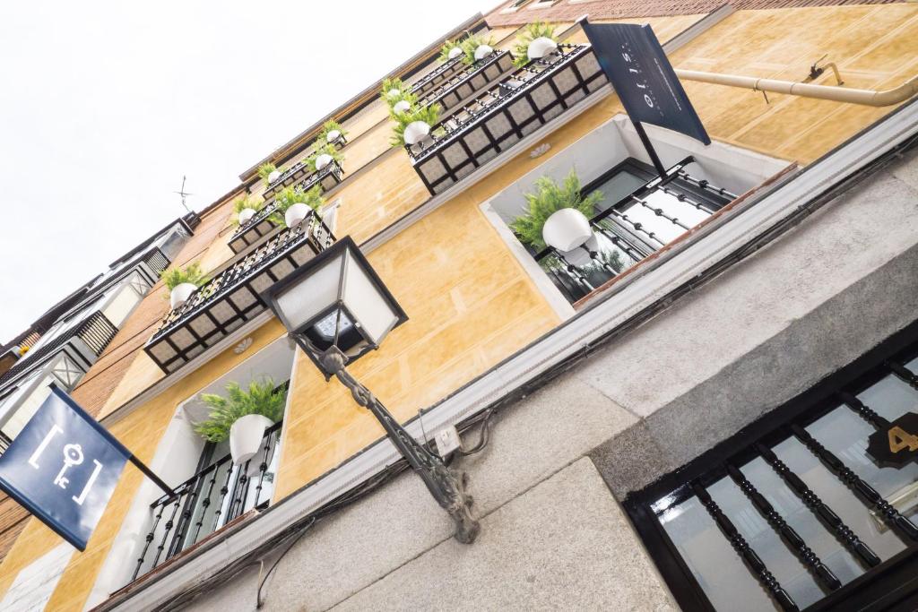 un edificio con 2 balcones y luz de la calle en Oriente Suites, en Madrid