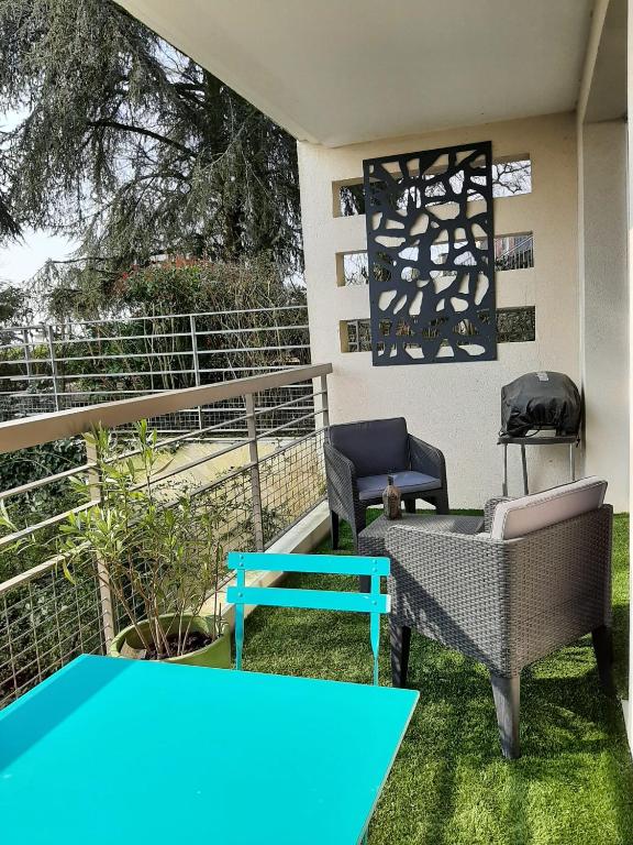 une terrasse avec 2 chaises et une table bleue dans l'établissement Chambre entre plage et Stade Vélodrome, à Marseille
