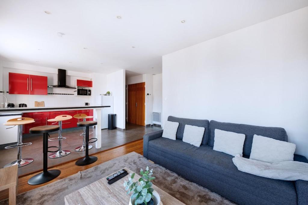 un salon avec un canapé et une cuisine dans l'établissement Charmant T3 au Cœur de Lyon 7ème, à Lyon