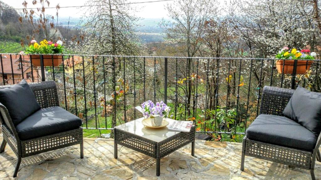 un patio con 2 sillas y una mesa con flores en Al Pörtec, en Sotto il Monte