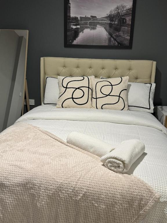 a bed with a white comforter and pillows at Ancoats 2BR with Private terrace in Manchester