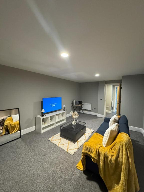 a living room with a blue couch and a tv at Ancoats 2BR with Private terrace in Manchester