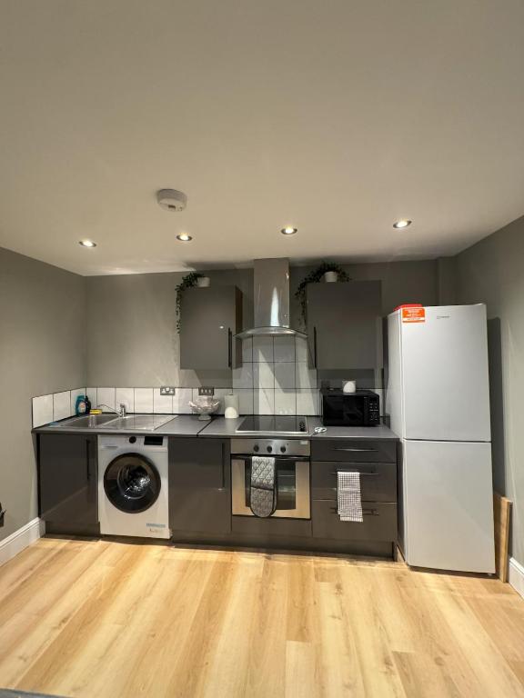 a kitchen with a stove and a refrigerator at Ancoats 2BR with Private terrace in Manchester