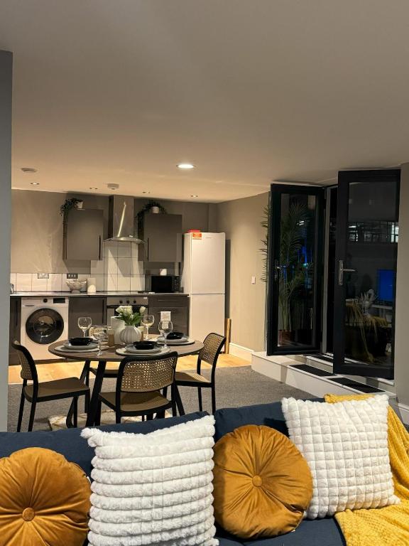 a living room with a table and a kitchen at Ancoats 2BR with Private terrace in Manchester