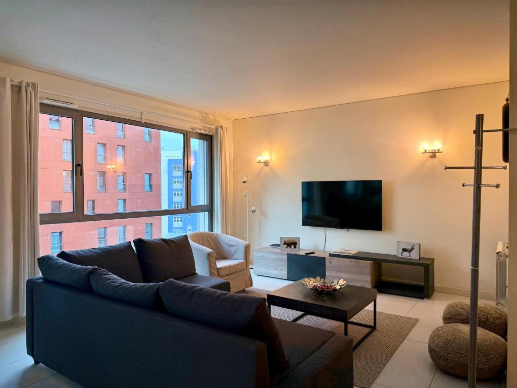 Hotel Fernando Pessoa Expo, a living room with a couch and a flat screen tv at Fernando Pessoa Expo in Lisbon