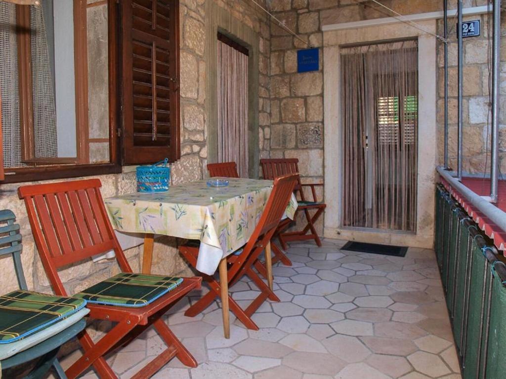 a table and chairs on a patio with a table at Apartment Simi in Postira