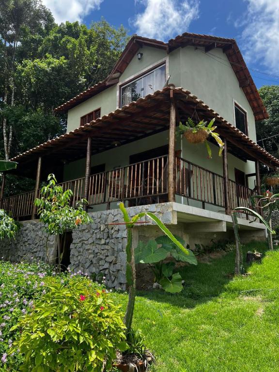 a house with a porch and a balcony at Bangalô império verde in Chã Grande