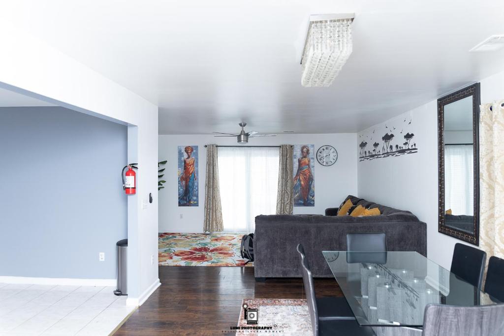 ニューアークにあるBeautifully Designed & Spacious Apartment in Newark 10mins from EWR Airport, Close to NYC and Beth Israel Hospitalのソファとガラスのテーブルのあるリビングルーム