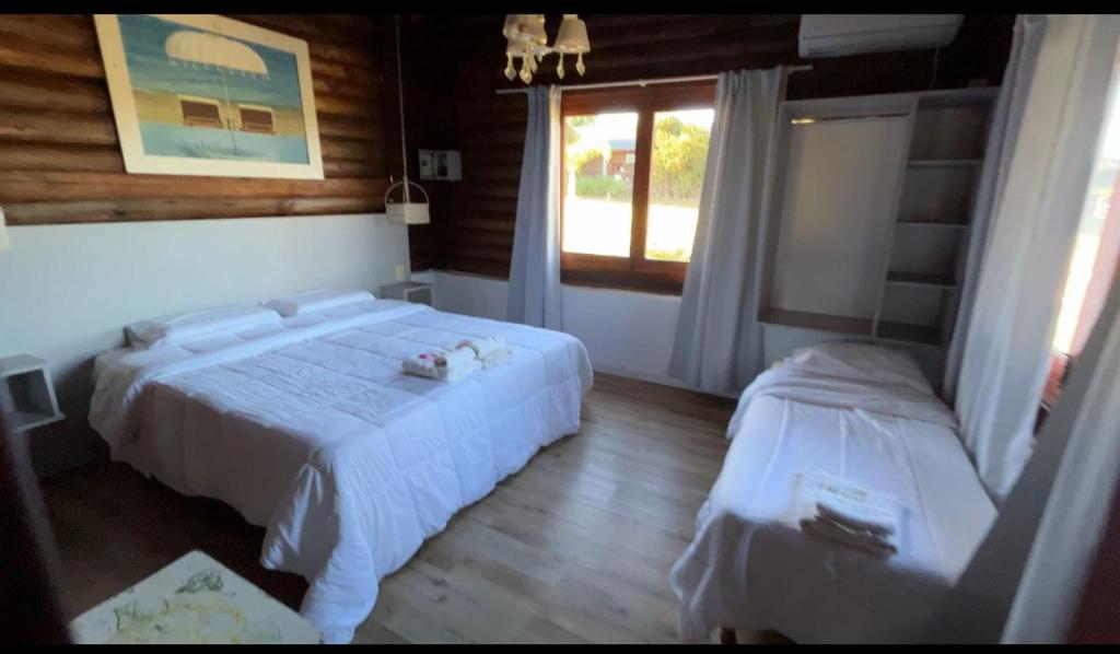 een slaapkamer met twee bedden en een raam bij Los Origenes Lodge Hotel in Concordia